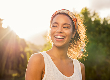 Young african woman smiling at sunset